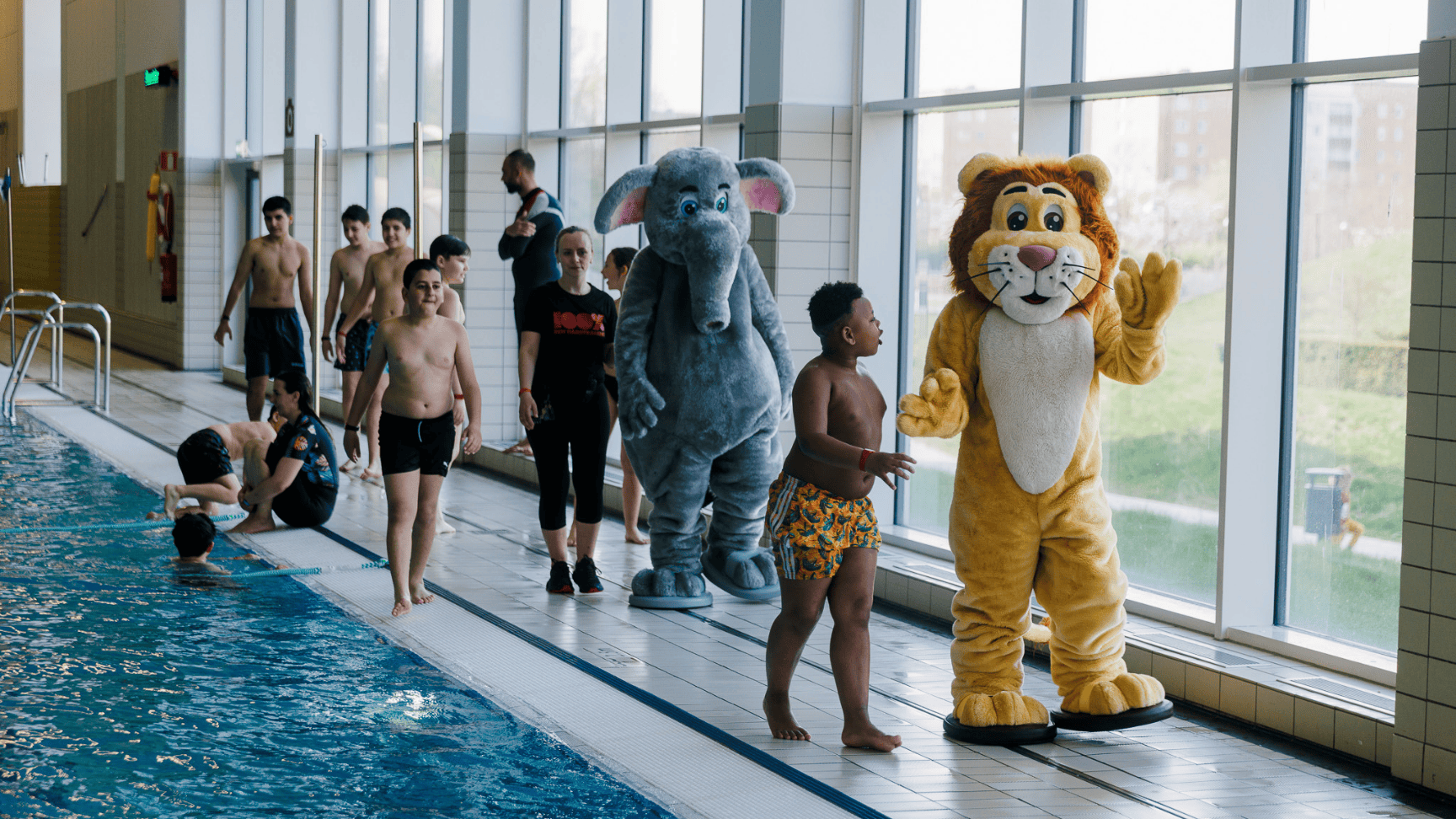 En person iförd en färgglad sjöjungfrudräkt simmar under vattnet på Hylliebadet.