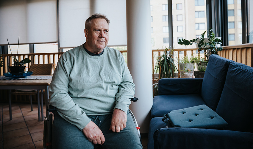 Jocke har en ljusgrön långärmad tröja. Han sitter på boendets balkong.