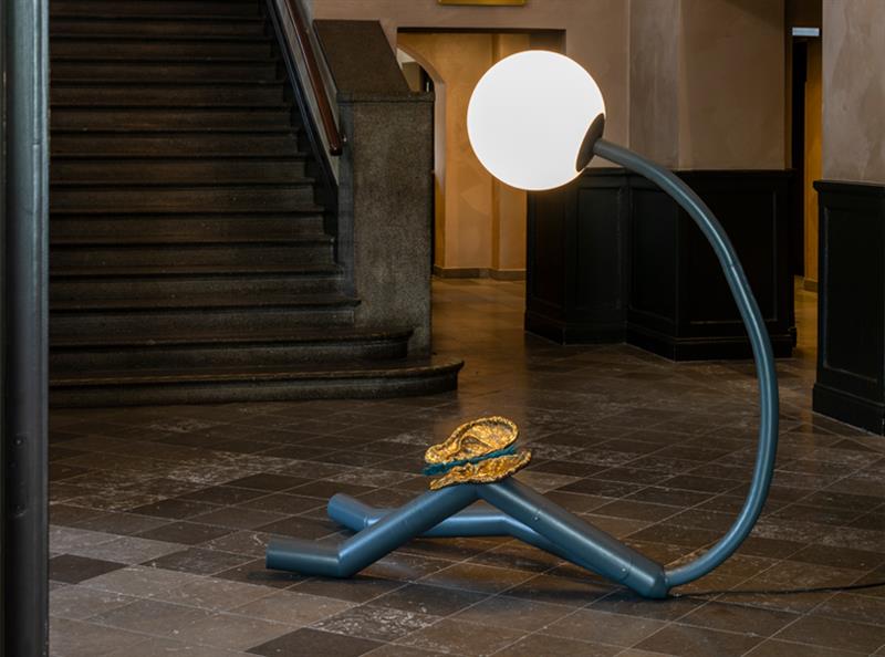 Bild på verket Solitude. En lampa som efterliknar en människa med öron på knäna.