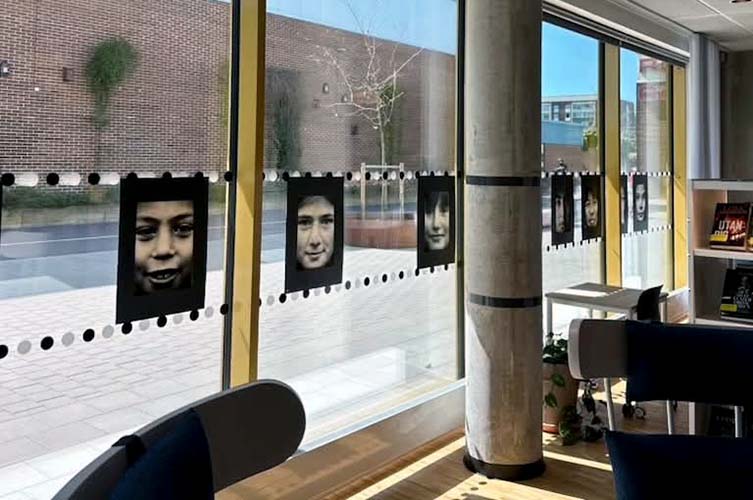Fotoutställning uppsatt i fönstren på Rosengårdsbiblioteket.