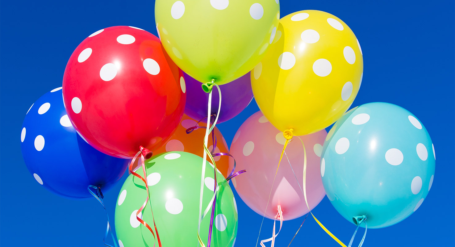 Nio svävande ballonger i olika färger.