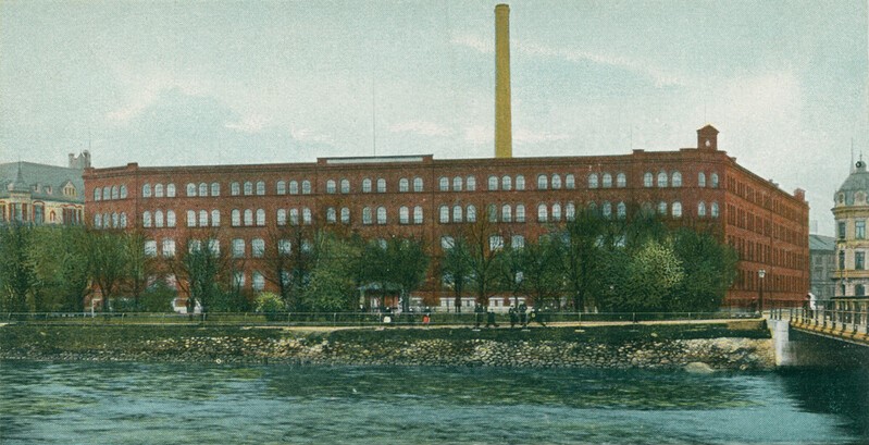 Stor röd tegelbyggnad längs kanalen.