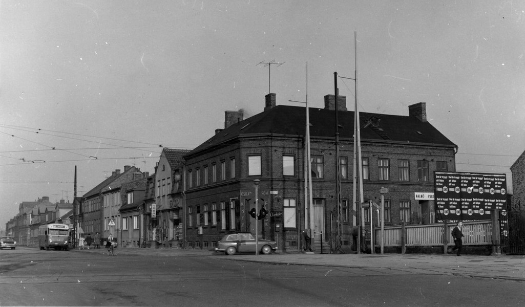 En gammal svartvit bild av ett gatuhörn, som fångar tidens atmosfär och historiska detaljer.