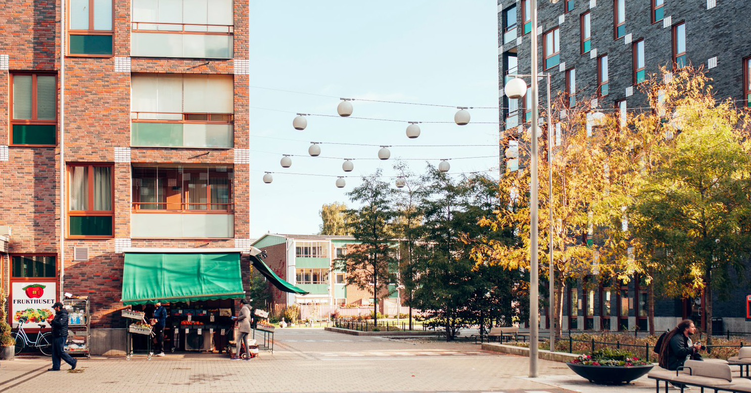 Visar en bild på torget som Holmastigen passerar. Syns bland annat en fruktaffär. 