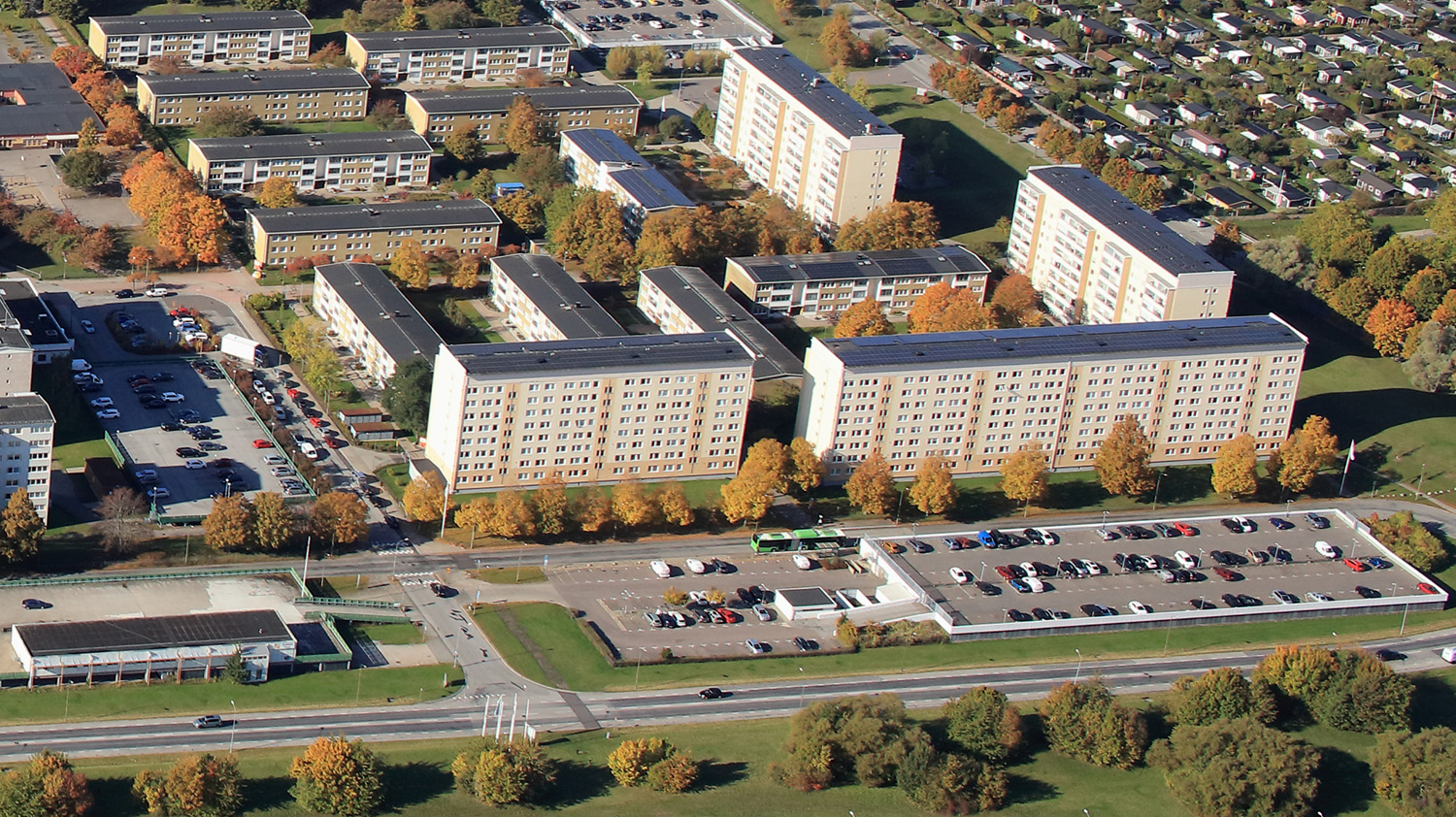 En flygbild tagen på norra delen av Holma där man ser bostadshus samt parkeringsplats uppifrån. 