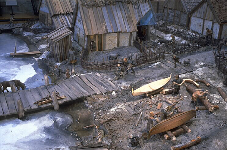 En modell över vikingastaden Birka som visar träbryggor och små lastbåtar.