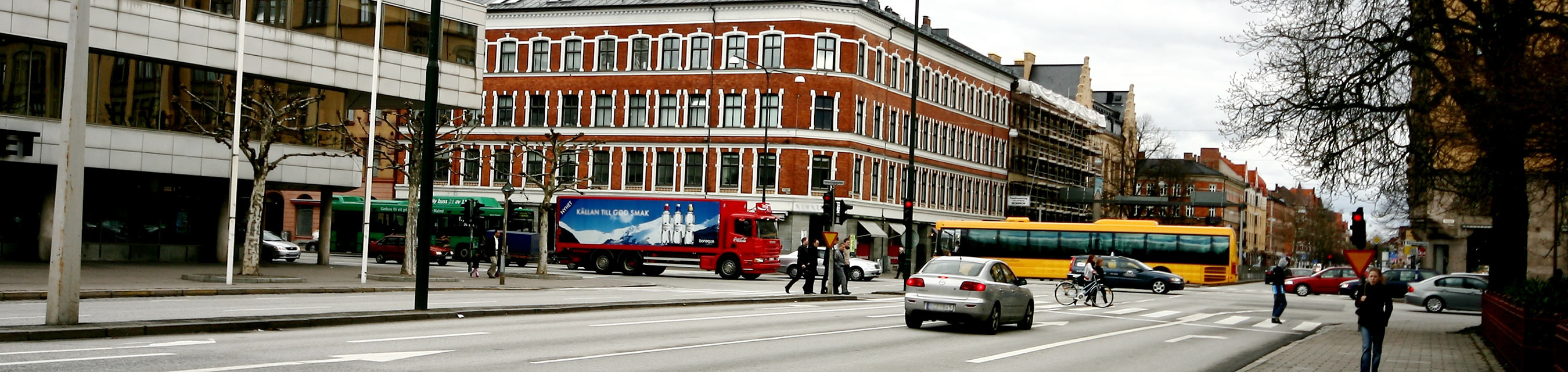 Trafikkorsning i Malmö med bilar, bussar och fotgängare.