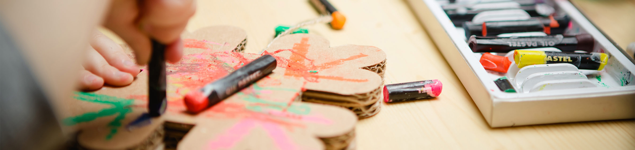 Närbild på en barnhand som målar med kritor. 