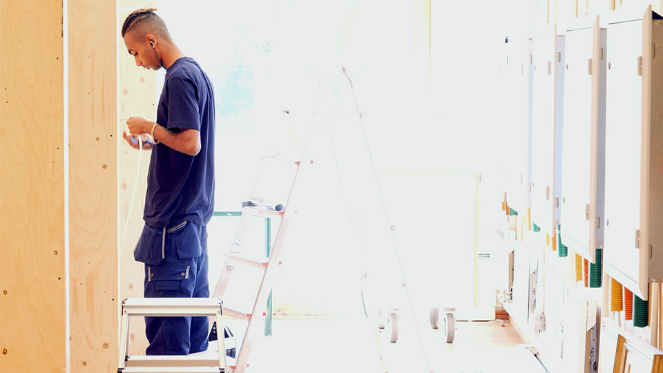 Elev står i elverkstad som är starkt upplyst av solljuset.