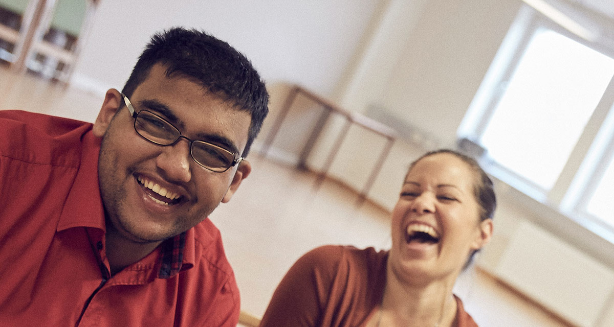 En elev och en lärare skrattar tillsammans.