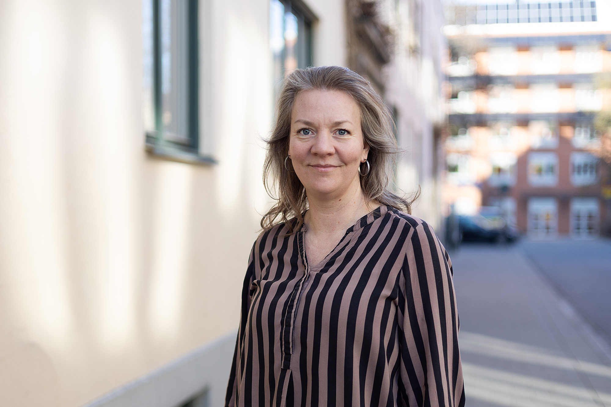 Linnea Folkesson har medellångt hår och en randig skjorta.