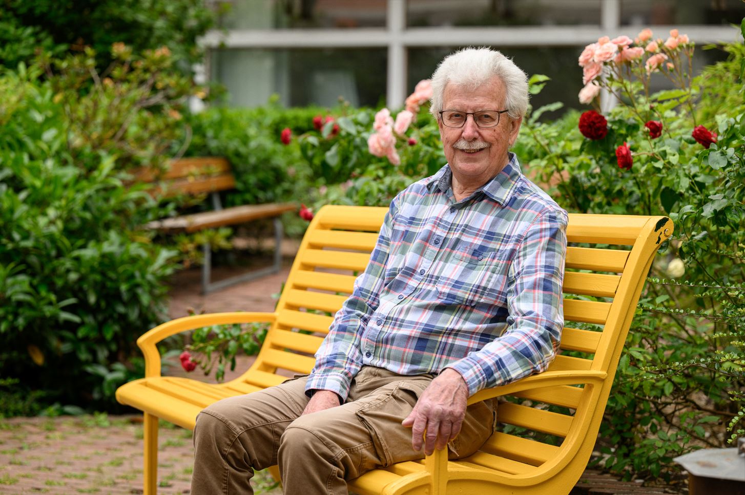 Bosse sitter på en gul vänskapsbänk.