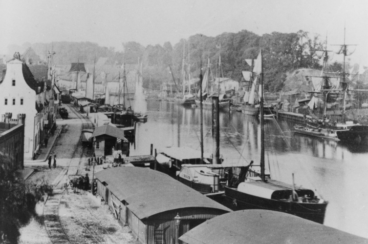 Äldre foto på hamn med fartyg.