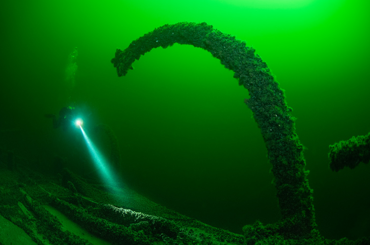 På fotografiet är havet klargrönt och det växer musslor på vrakdelarna.