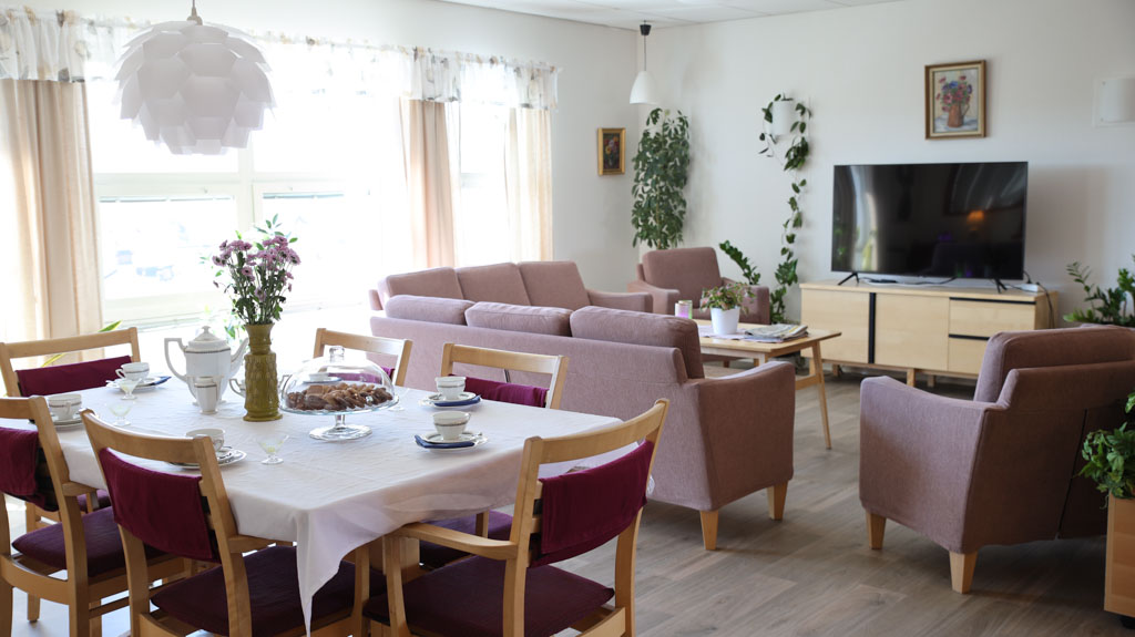 I gemenskapsrummet finns plats både för den som vill ta en kopp kaffe vid matbordet eller föredrar att sjunka ner i de rosa mjuka fåtöljerna och titta en stund på TV.