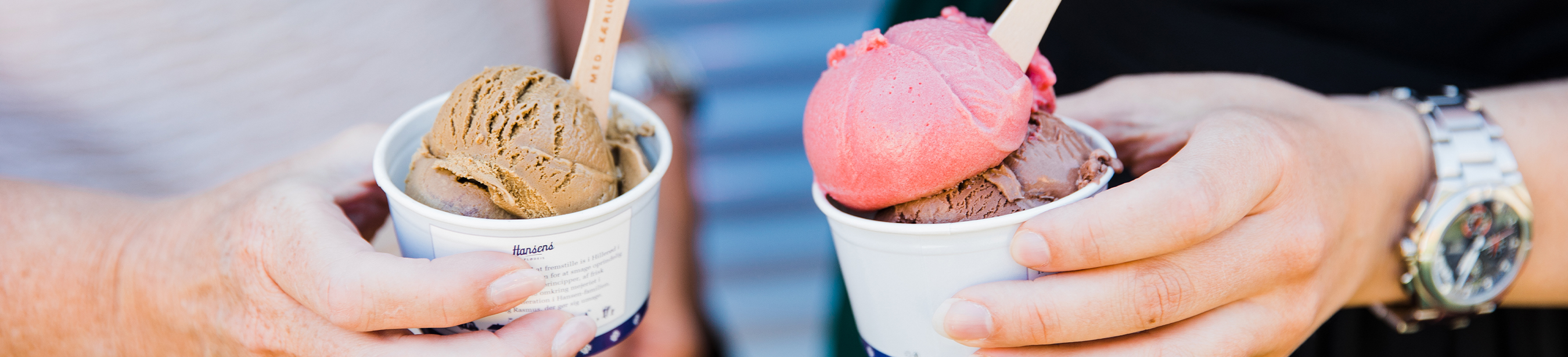 två personer håller varsin bägare med glass