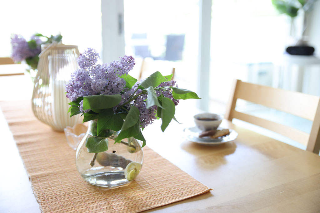 En bukett syrener från trädgården på bordet piggar upp fikastunden.