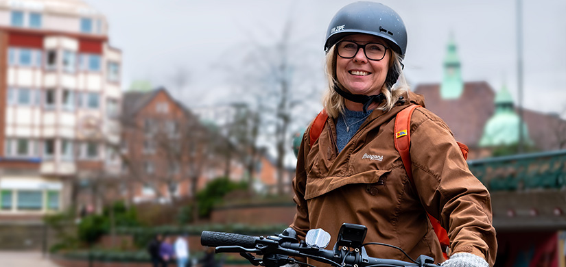 Kvinna med cykelhjälm och cykel