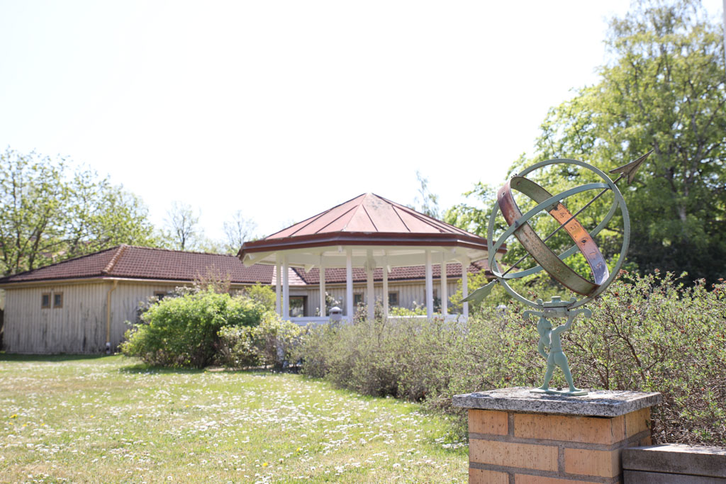 I den gröna trädgården står ett lusthus där man kan vila sig en stund.