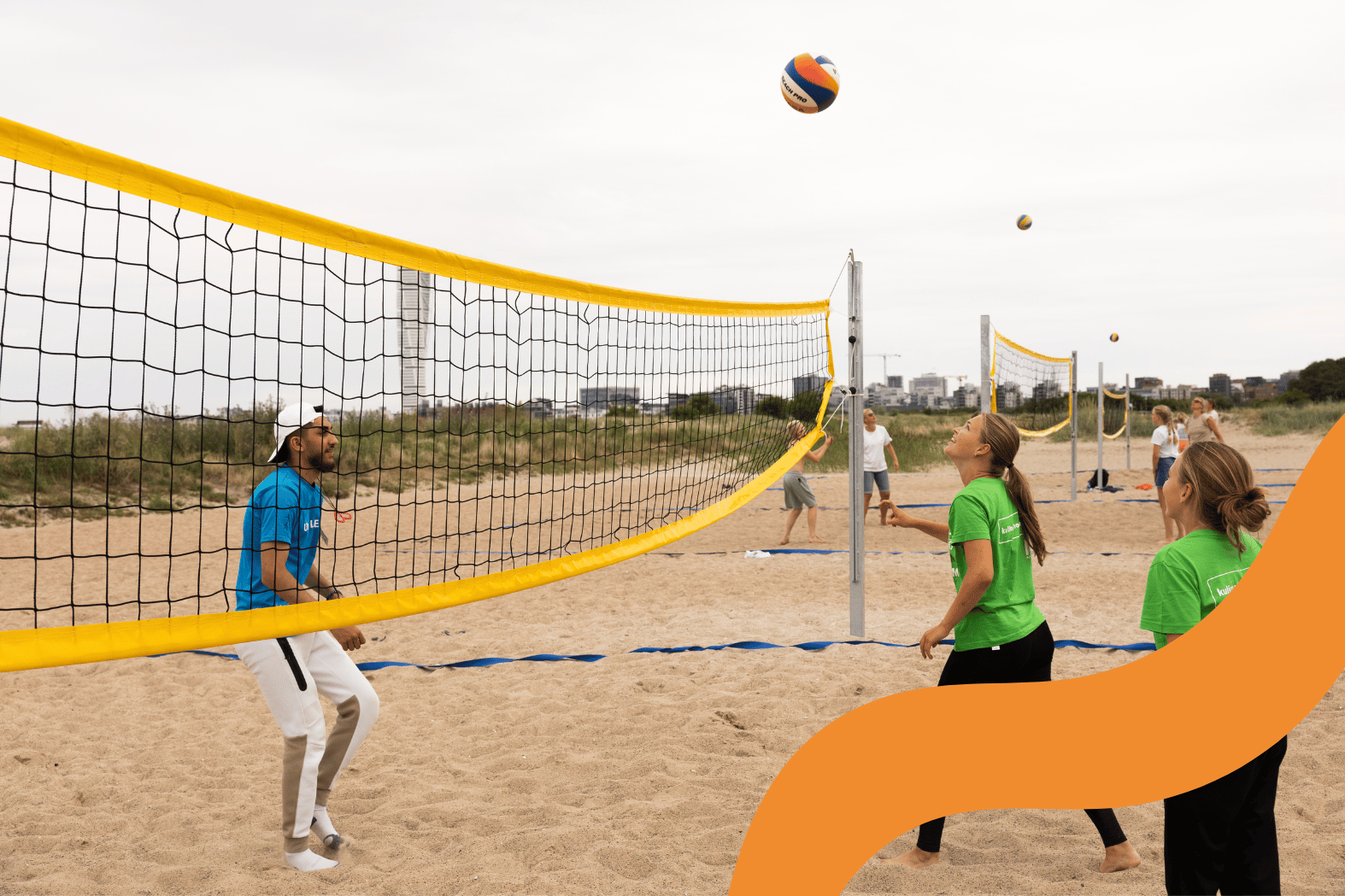 Flera personer spelar beachvolleyboll på stranden.