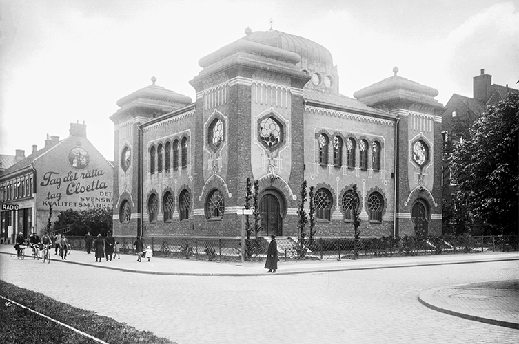 Äldre svartvitt foto på synagogan i stadsmiljö.
