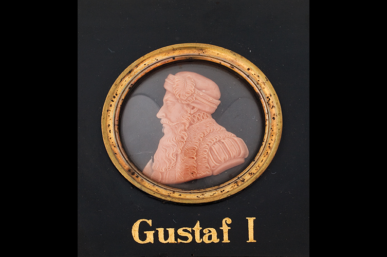 Porträttmedaljong, i vax,
bröstbild föreställande Gustav Vasa infattad i rund ram av förgylld mässing och
svartmålad fyrsidig träplatta. Foto: Matilda Thulin / Malmö Museer.