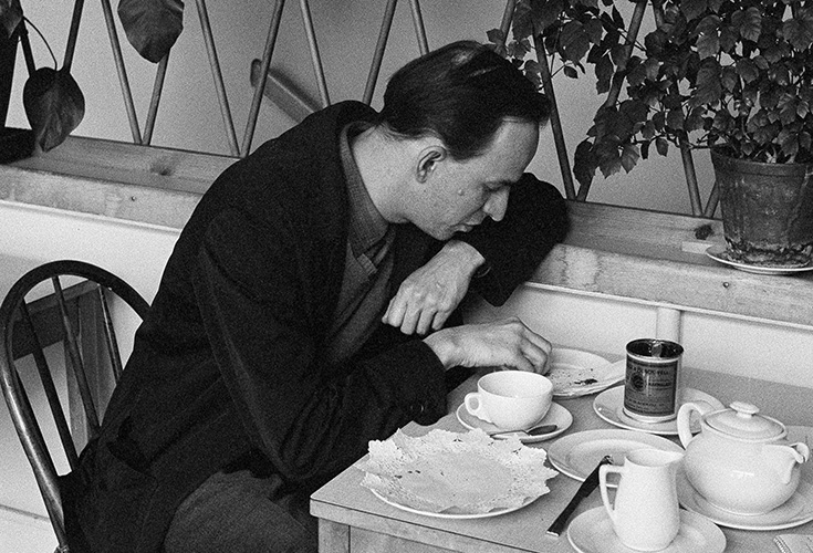 Äldre svartvitt foto på Ingmar Bergman som dricker kaffe.