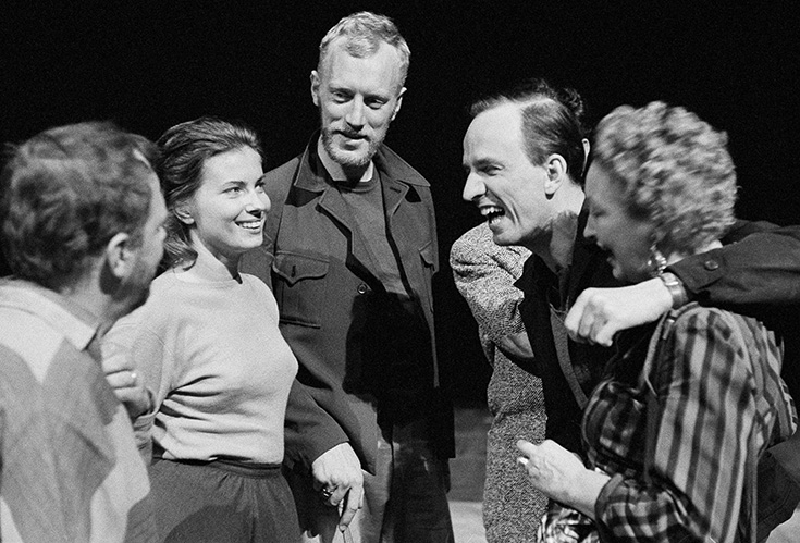 Äldre svartvitt foto på Ingmar Bergman och kollegor som pratar och skrattar.