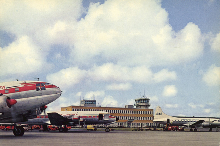 Fotografi från en flygplats. På bilden syns två röda och vita flygplan, samt ett vitt SAS-flygplan. 