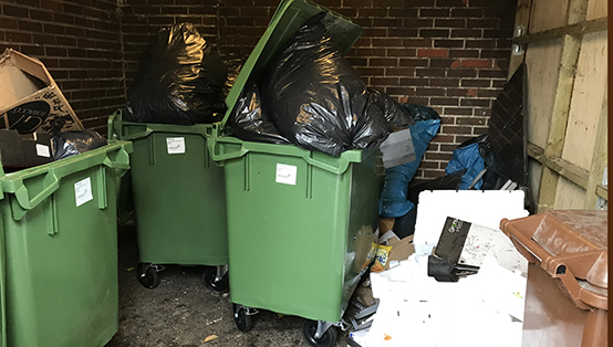 Överfulla kärl, sopor och matspill i rum för avfall