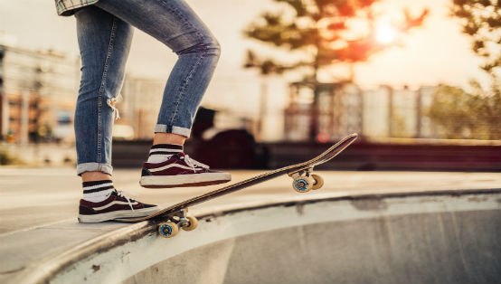 fötter på kanten av en skateboard på en skateboardramp