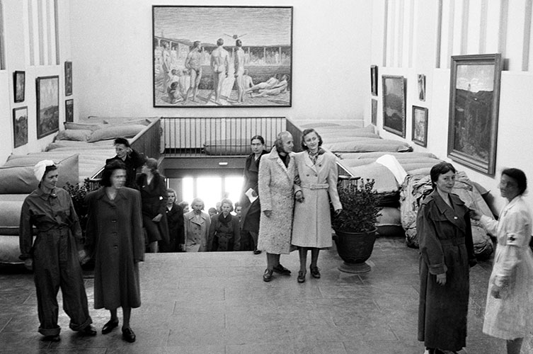 Äldre svartvitt fotografi av flyktingar på museet.