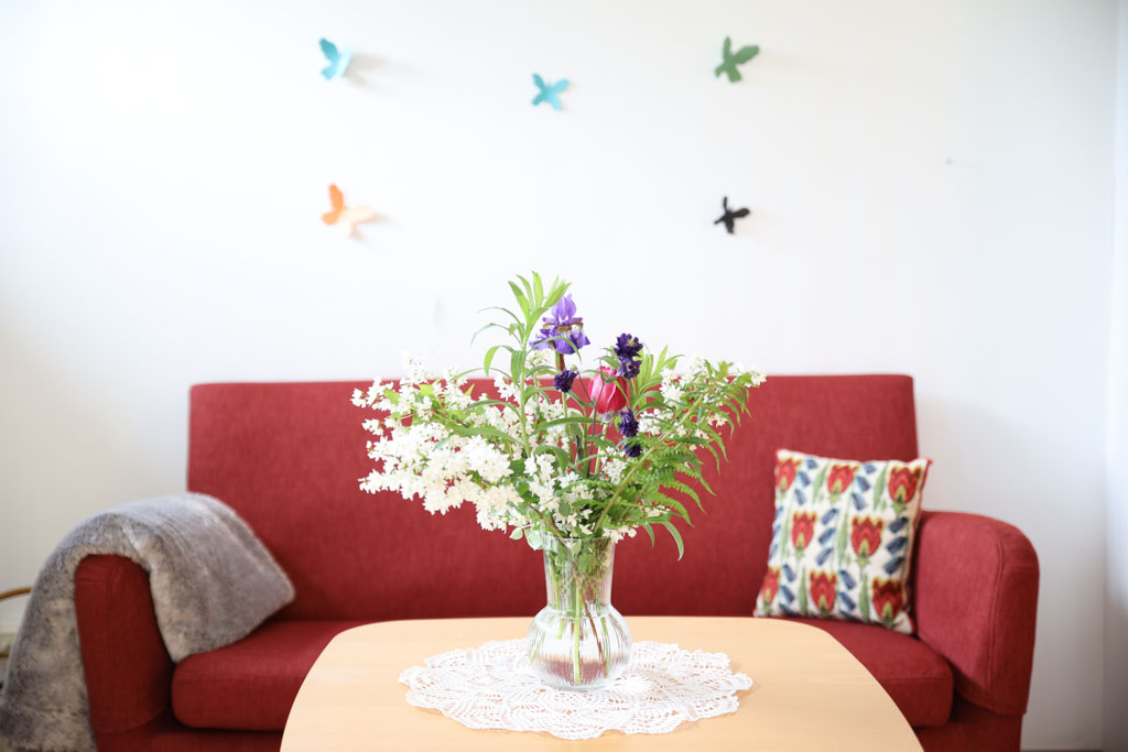 Fjärilarna ovanför den mjuka soffan ger ett lekfullt intryck.