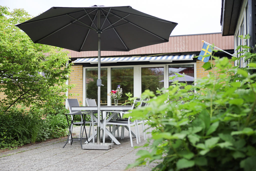 Under det stora parasollet finns en behaglig plats för umgänge utomhus.