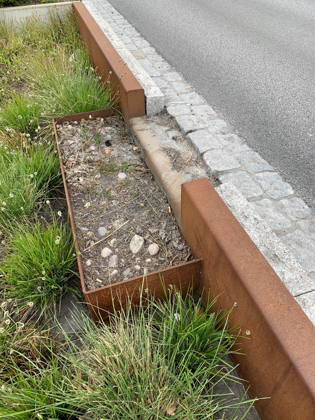 En utsänkning från trottoaren till en yta med jord och gräs där vatten kan rinna ner.