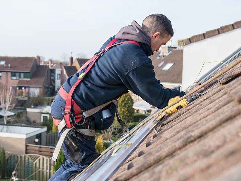 Montör installerar solceller på ett tak.
