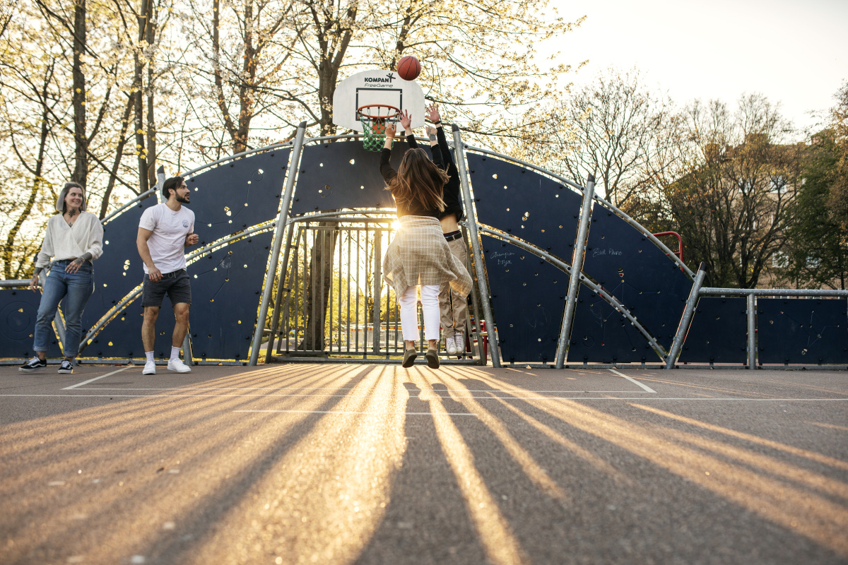Fyra personer som spelar basket på en multisportarena vid Enskifteshagen i Malmö.