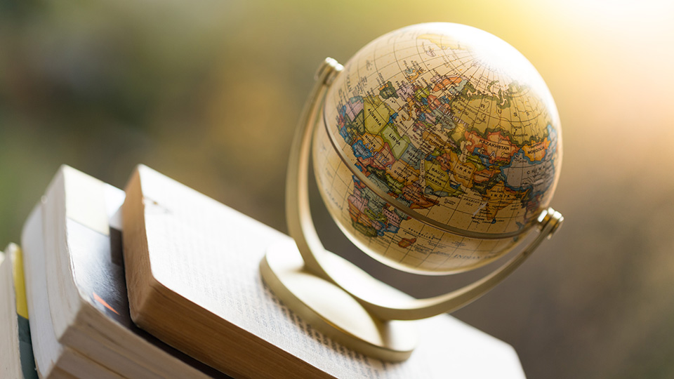 En jordglob på en trave böcker.