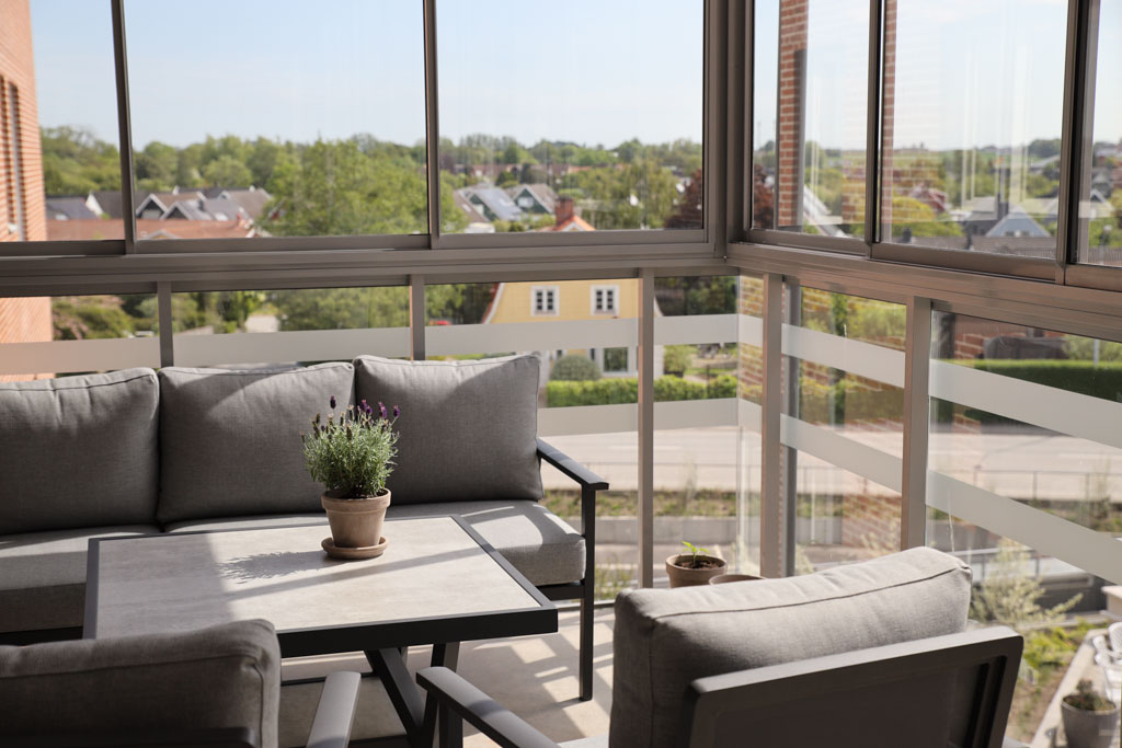 På de inglasade balkongerna kan man sitta och njuta
i soffgrupper och blicka ut över hus och åkrar.