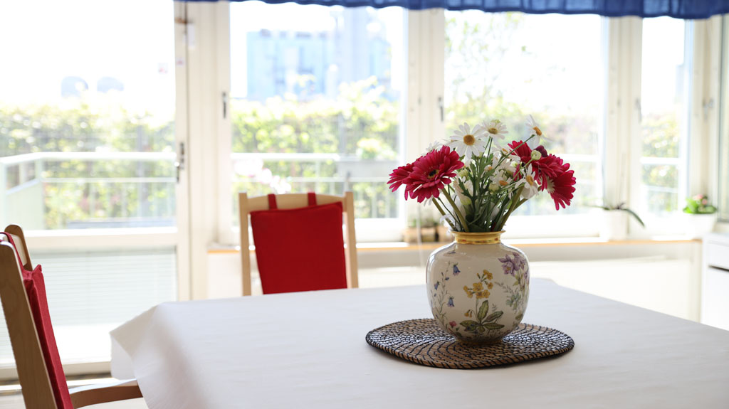 Somriga blommor i en vas på bordet ger en hemtrevlig känsla.