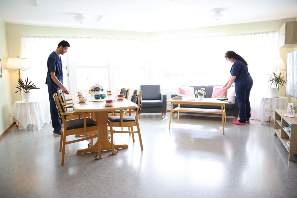 Personal förbereder ett dukat bord och ställer i ordning.