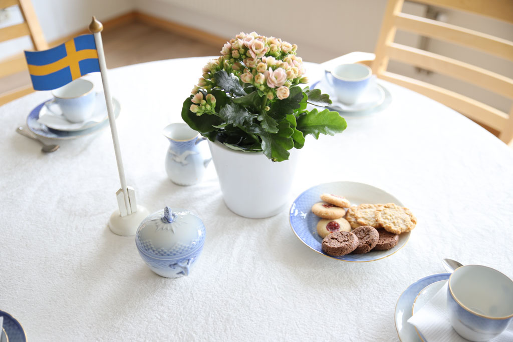 Klassiskt porslin, blommor, kakor och flagga har tagits fram på bordet till fikan.