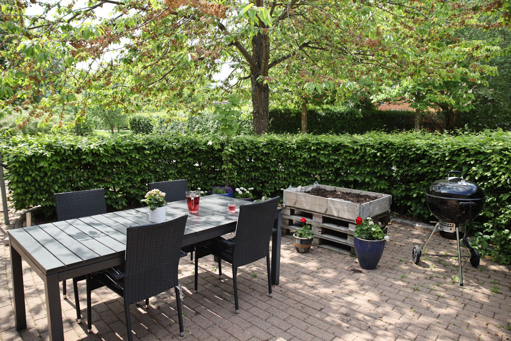 På uteplatsen kan man grilla och umgås i skuggan av ett träd.