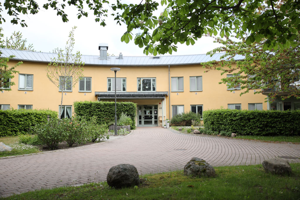 En stensatt gång leder fram till den gula tvåvåningsbyggnaden med
ljusgröna detaljer.