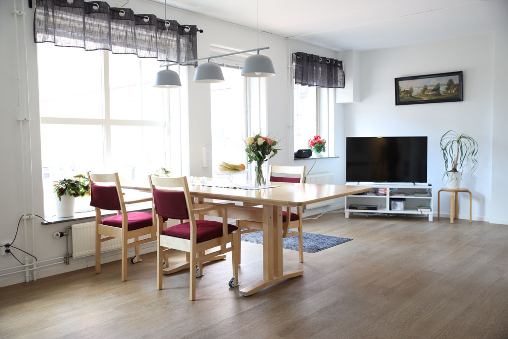 Matsalsbordet är placerat vid ett stort fönster som man kan titta ut genom när man äter middag. Men i bakgrunden finns även en TV för den som hellre tittar på det.