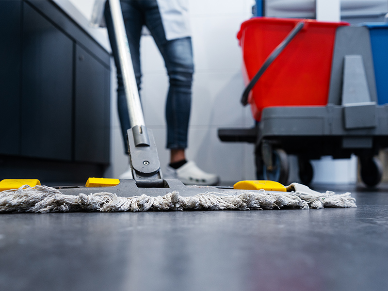 En person moppar golvet.
