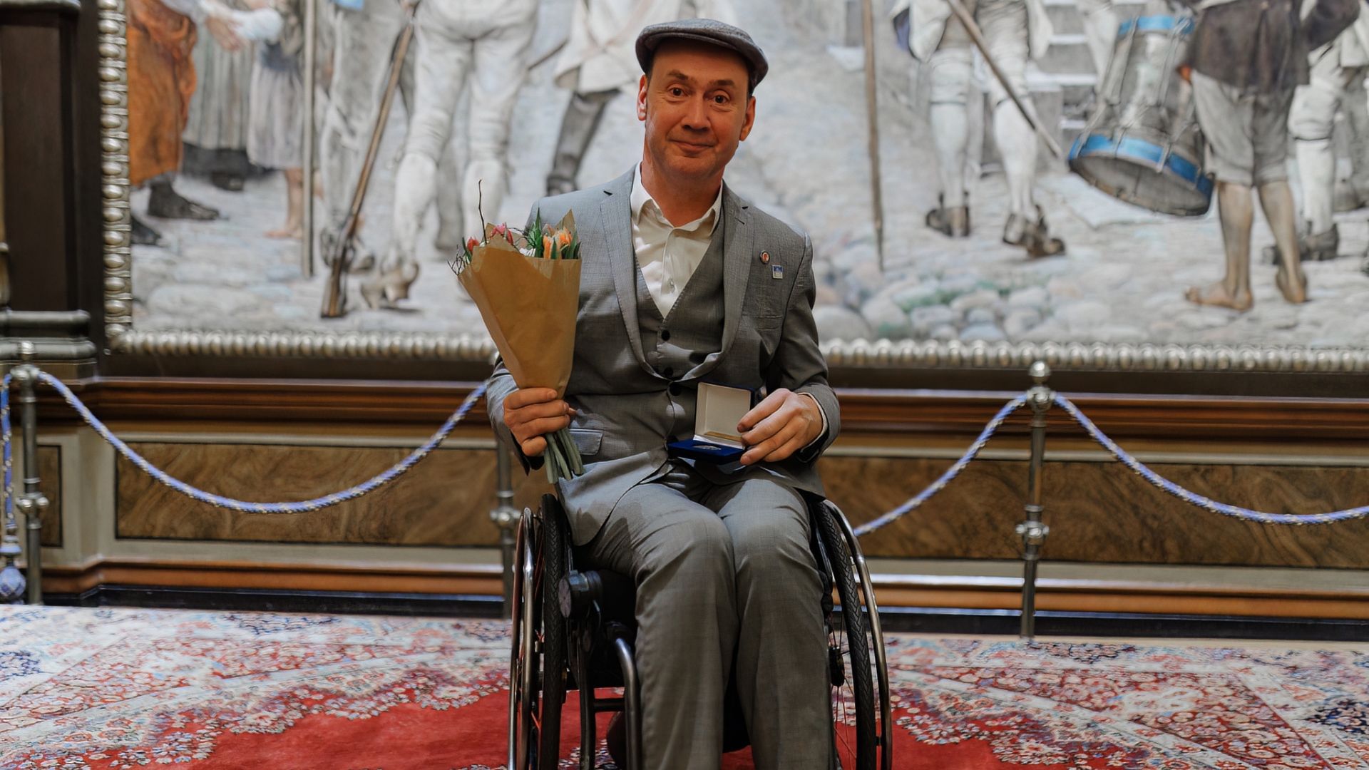 Peter Molander har tagit emot medalj och blommor. Han sitter i rullstol.