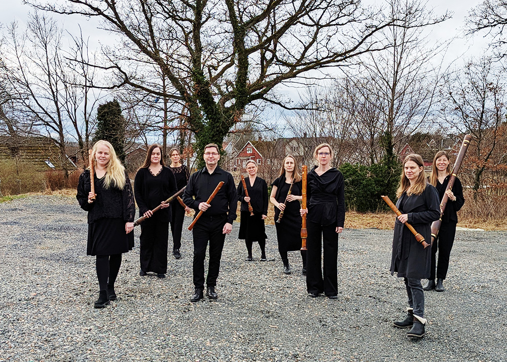En grupp musiker står utomhus med sina instrument i händerna.