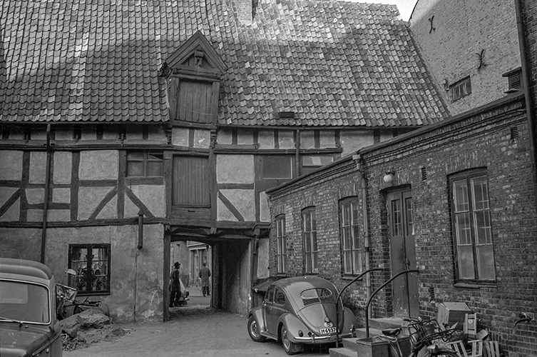 Fotografi på Hedmanska gården, ett korsvirkeshus, från 60-talet. Framför huset står en tidstypisk bil. 
