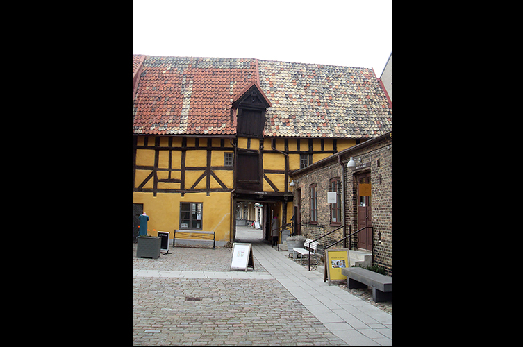 Fotografi på Hedmanska gården, ett gult korsvirkeshus i två våningar.
